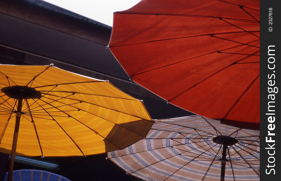 Red, yellow and striped umbrellas at Thailand marketplace. Red, yellow and striped umbrellas at Thailand marketplace