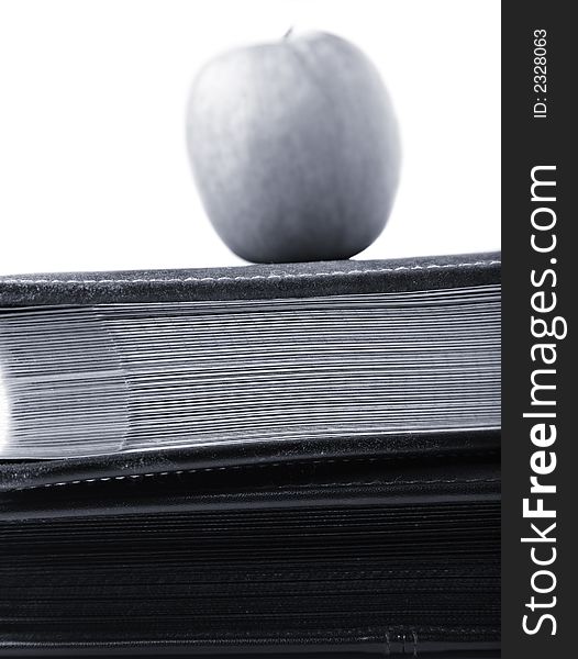 Black and white apple on top of books. Black and white apple on top of books.
