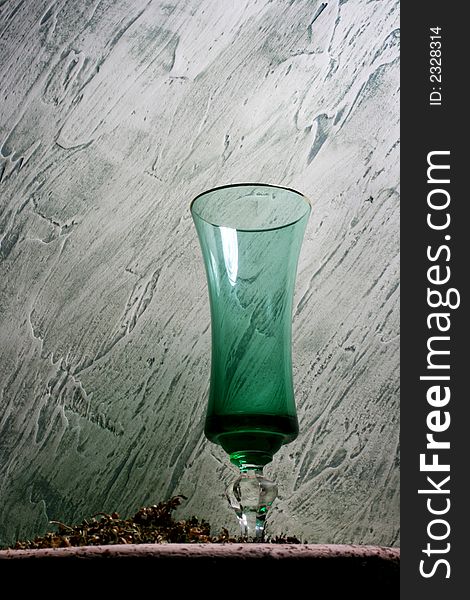 Green wine glass on a background to plaster