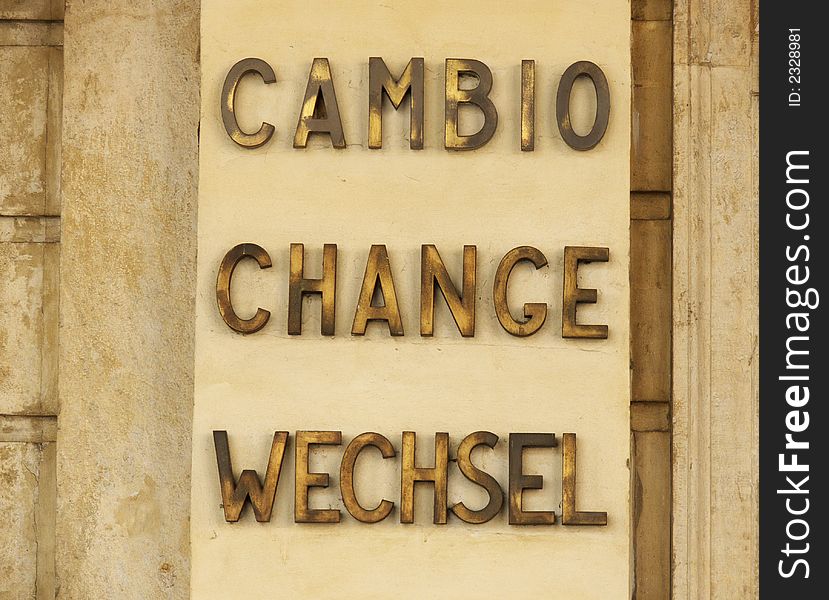 A sign for currency change in three languages: italian, englishand german. photo taken in an italian city.