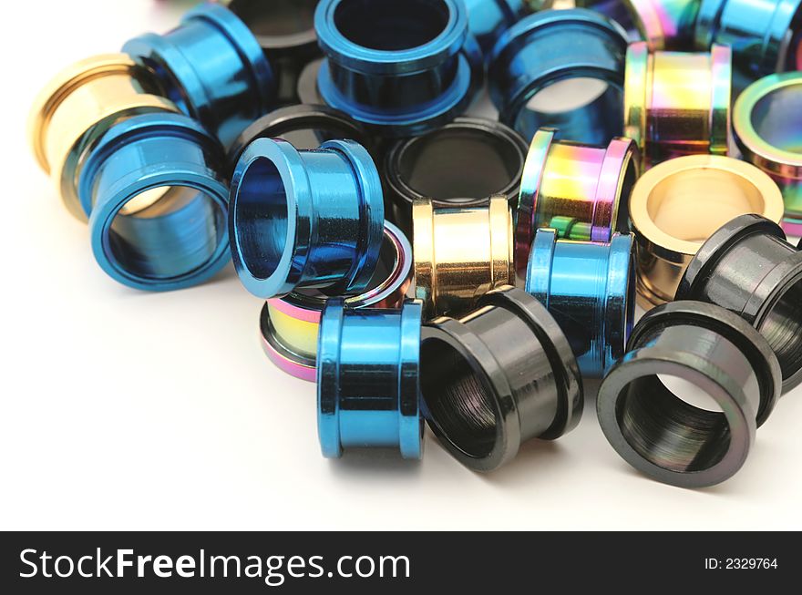 A big pile of colorful titanium on flesh tunnels. These are used in stretched ear lobes. A big pile of colorful titanium on flesh tunnels. These are used in stretched ear lobes.