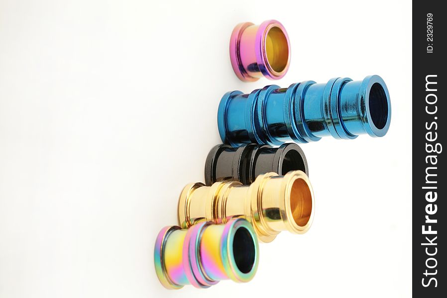 Five stacks of colorful titanium screw on flesh tunnels. These are used in stretched ear lobes. Five stacks of colorful titanium screw on flesh tunnels. These are used in stretched ear lobes.