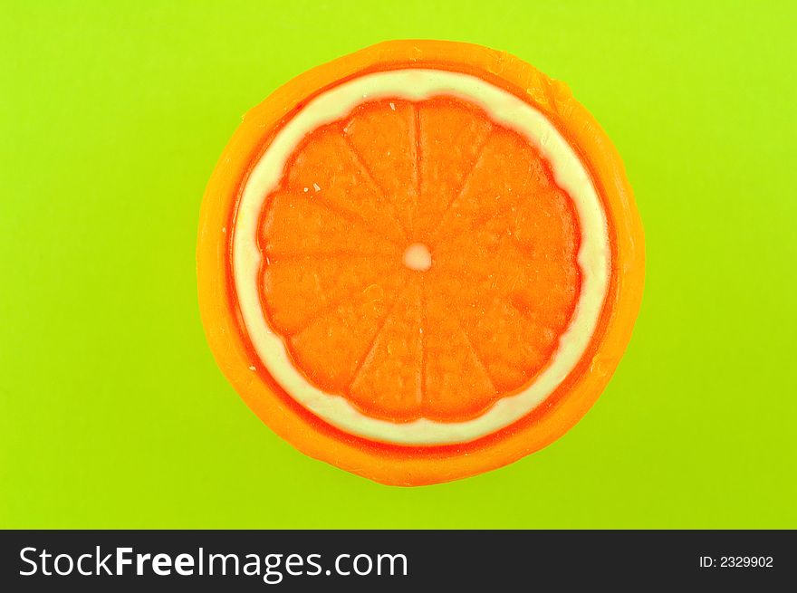 Soap in the shape of an orange isolated on a lime green background. Soap in the shape of an orange isolated on a lime green background