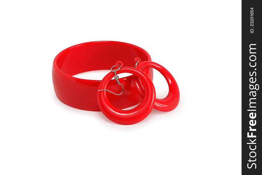 Red plastic bangle and pair of earring on white background. Isolated with clipping path. Red plastic bangle and pair of earring on white background. Isolated with clipping path