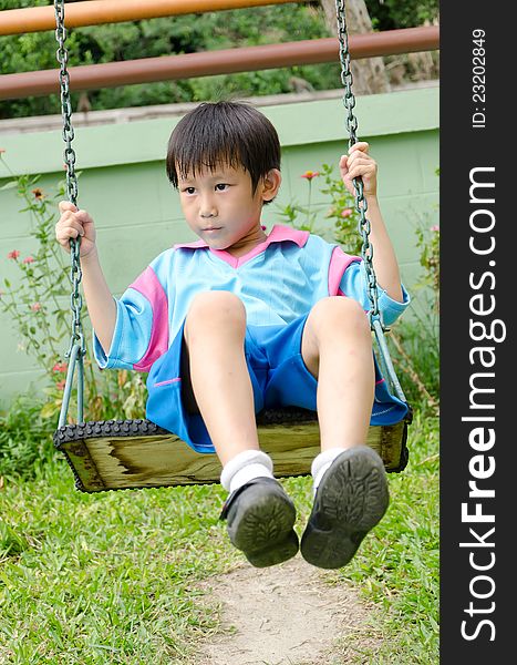 Asian boy playing swing outdoor