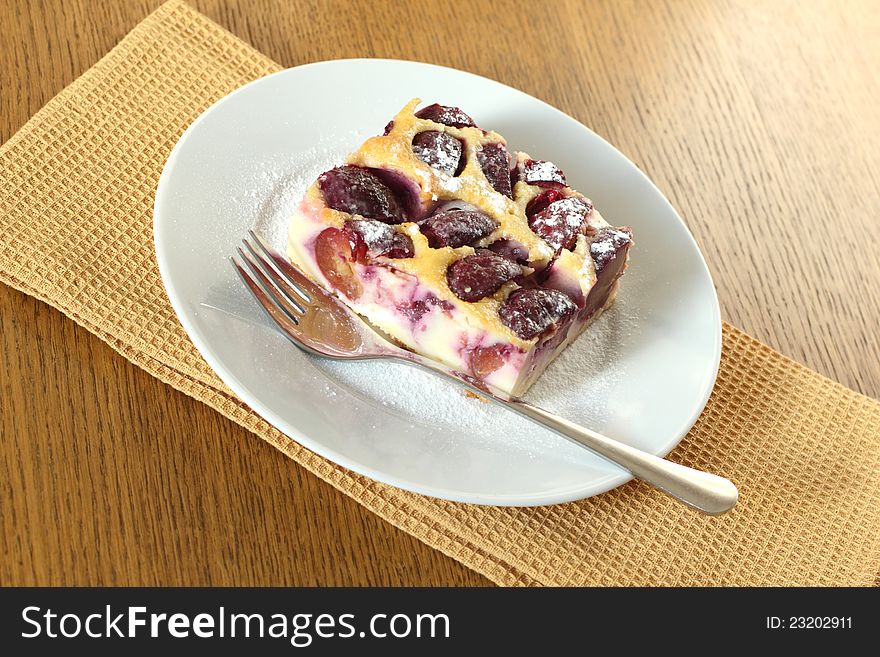 Clafoutis with plums Ð¾n a white plate