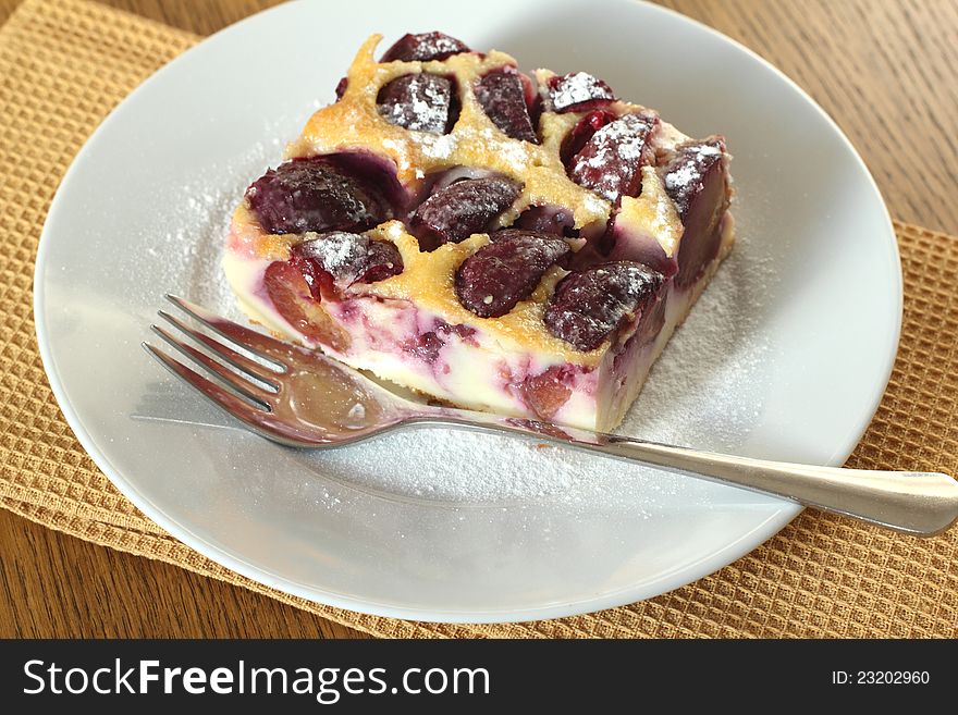 Clafoutis with plums оn a white plate