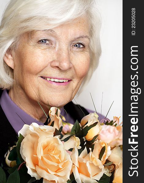 Senior woman portrait, smiling with a bunch of roses. Senior woman portrait, smiling with a bunch of roses