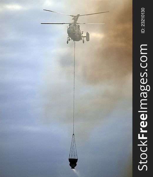 Helicopter extinguishes the fire with water. Helicopter extinguishes the fire with water