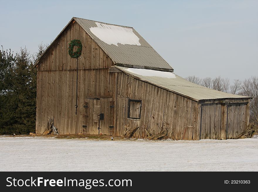 Old barn in winter with snow on ground and roof. Old barn in winter with snow on ground and roof