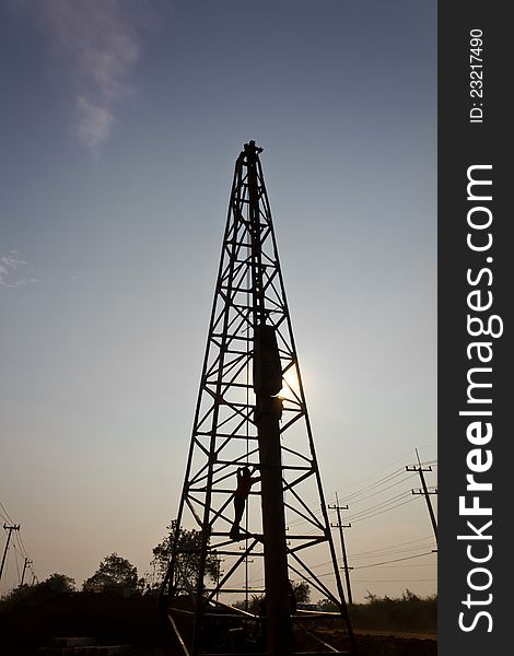 Silhouette of a worker in a Derrick, with sun shining through. Silhouette of a worker in a Derrick, with sun shining through.