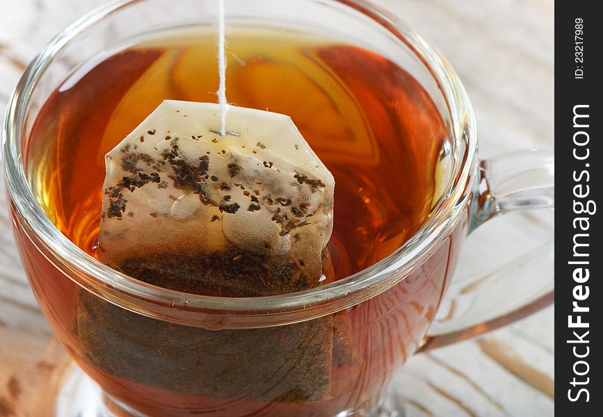 Teabag in the teacup on a wooden table. Teabag in the teacup on a wooden table