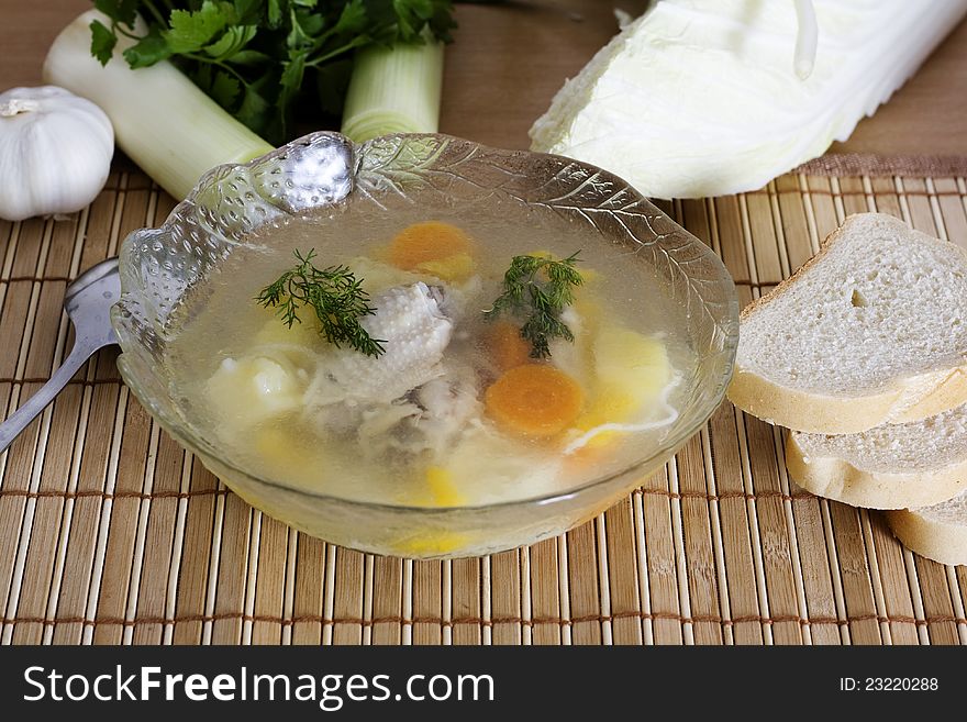 Plate of chicken soup vegetables on the background