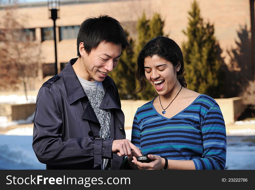 College Students with cell phone in School campus having fun