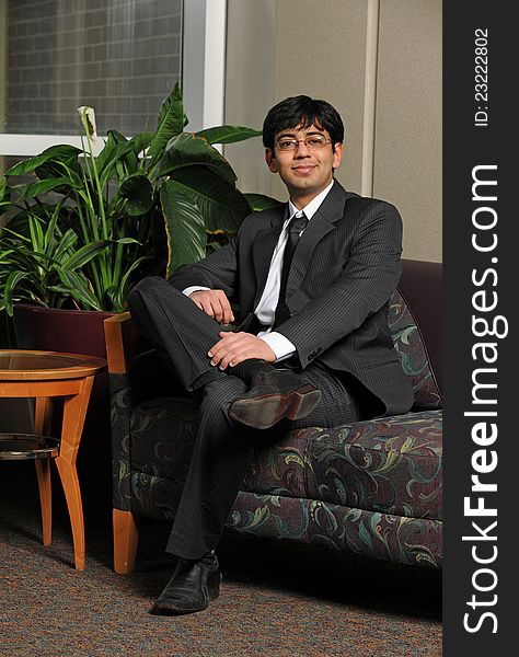 Young Eastern businessman sitting inside an office building