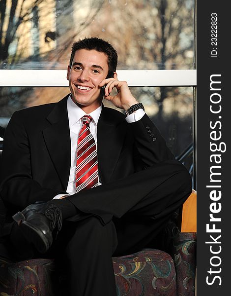 Young Businessman on the cell phone inside an office building