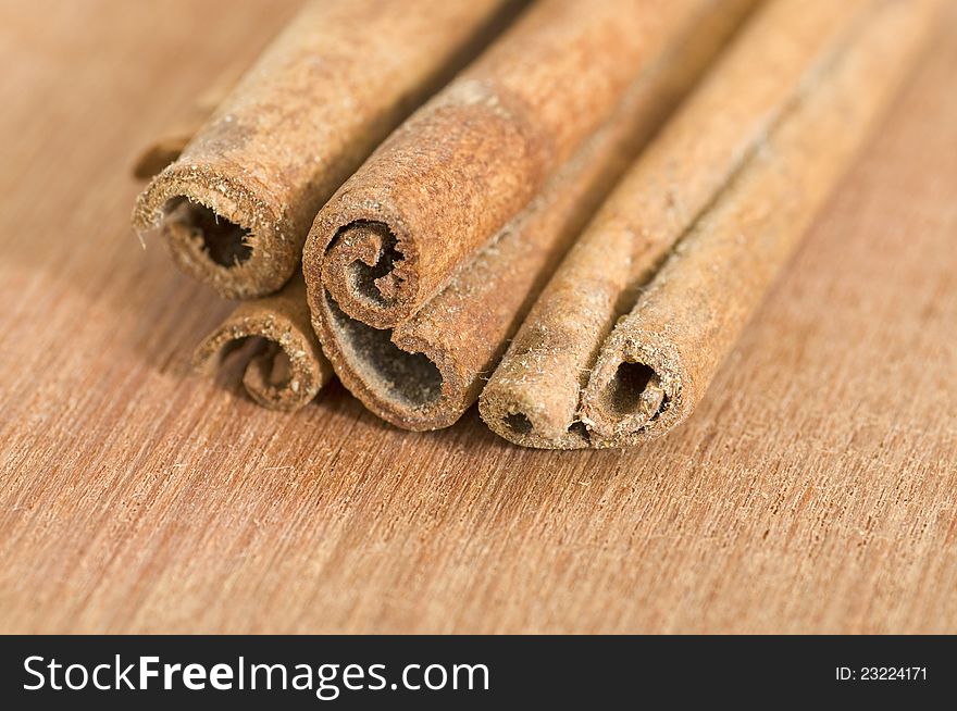 Group of cinnamon sticks shot over wooden background