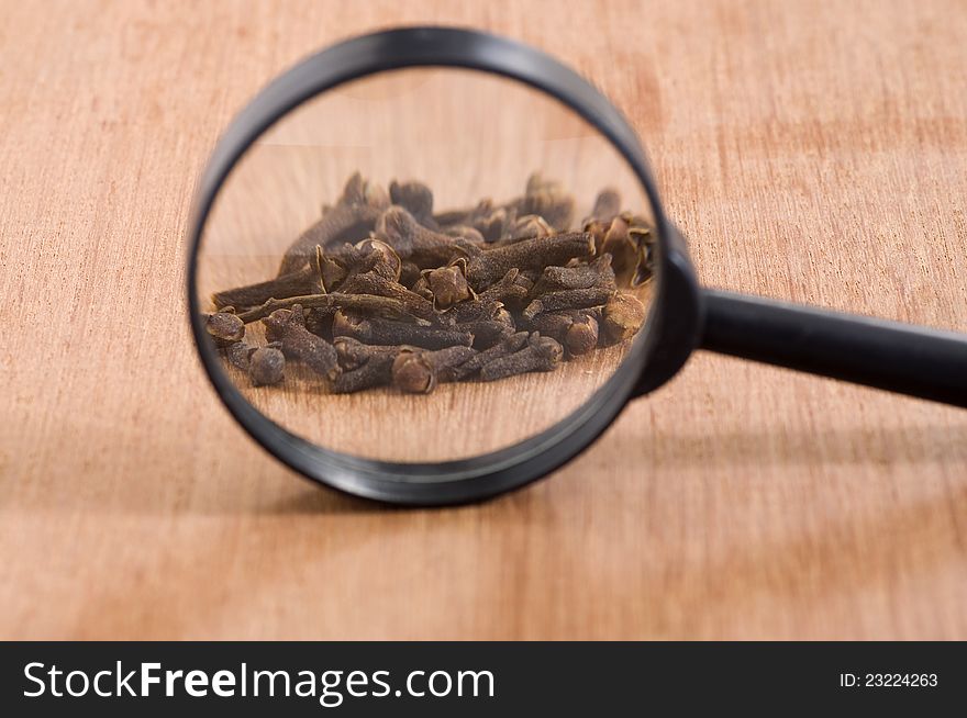 Cloves over wooden background and loop see the cloves. Cloves over wooden background and loop see the cloves