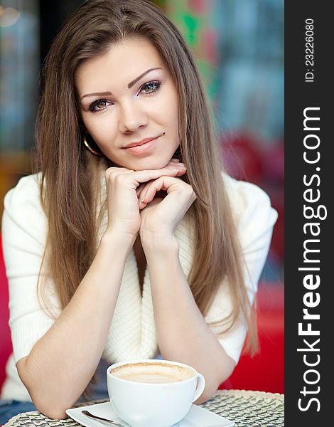 Beautiful Girl With Cup of Coffee in a cafe