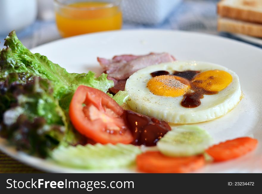 American style breakfast , with bacon, fried egg and fresh vegetables