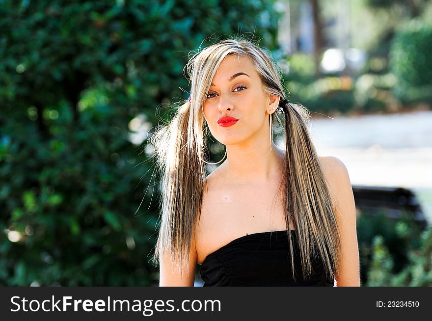 Beautiful and fashion girl with pigtails in the park