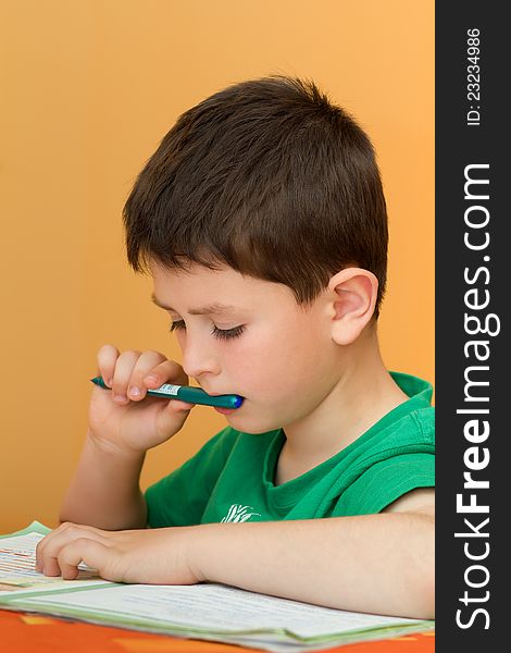 Boy thinking on homework from school in workbook. Boy thinking on homework from school in workbook