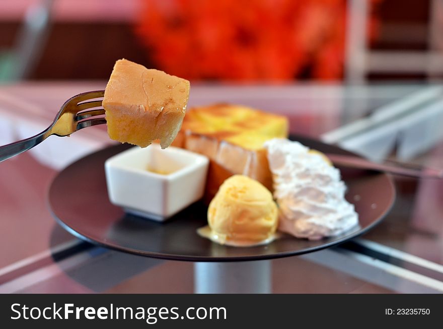 Close up toast  on fork , toast and whipping cream with vanilla ice cream  served with honey sauce. Close up toast  on fork , toast and whipping cream with vanilla ice cream  served with honey sauce