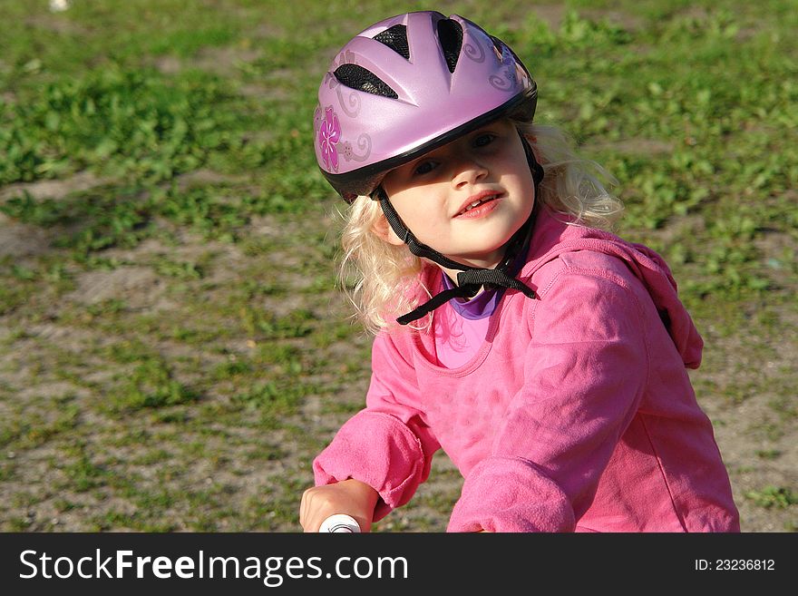 Cute little girl with a helmet riding a bike. Cute little girl with a helmet riding a bike