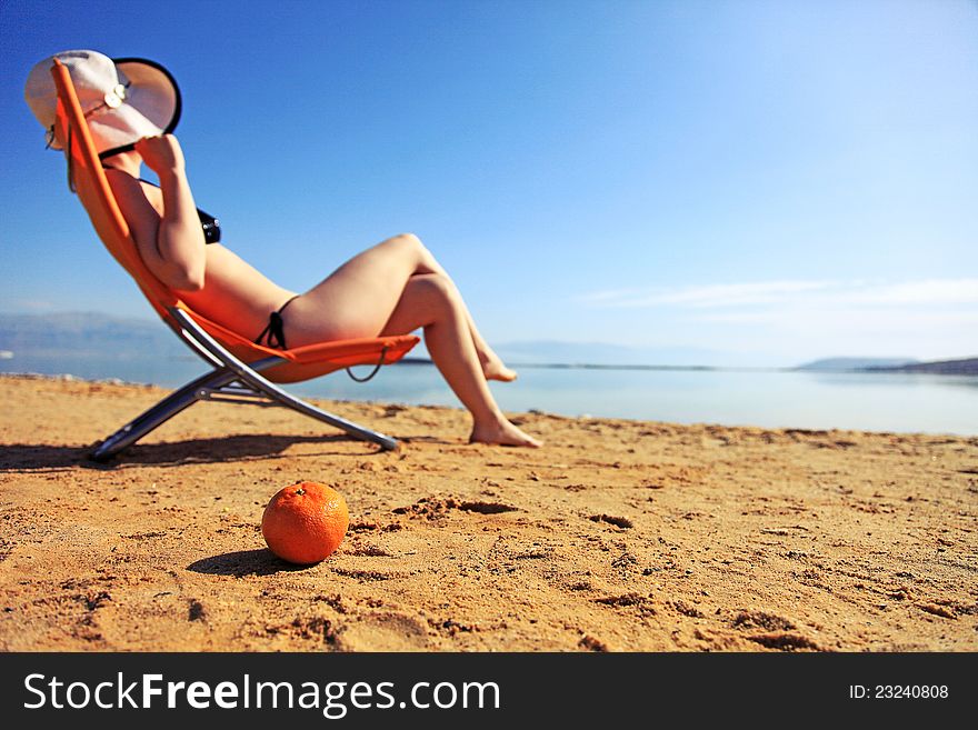 Girl sunbathing on the beach with warm summer day. Girl sunbathing on the beach with warm summer day