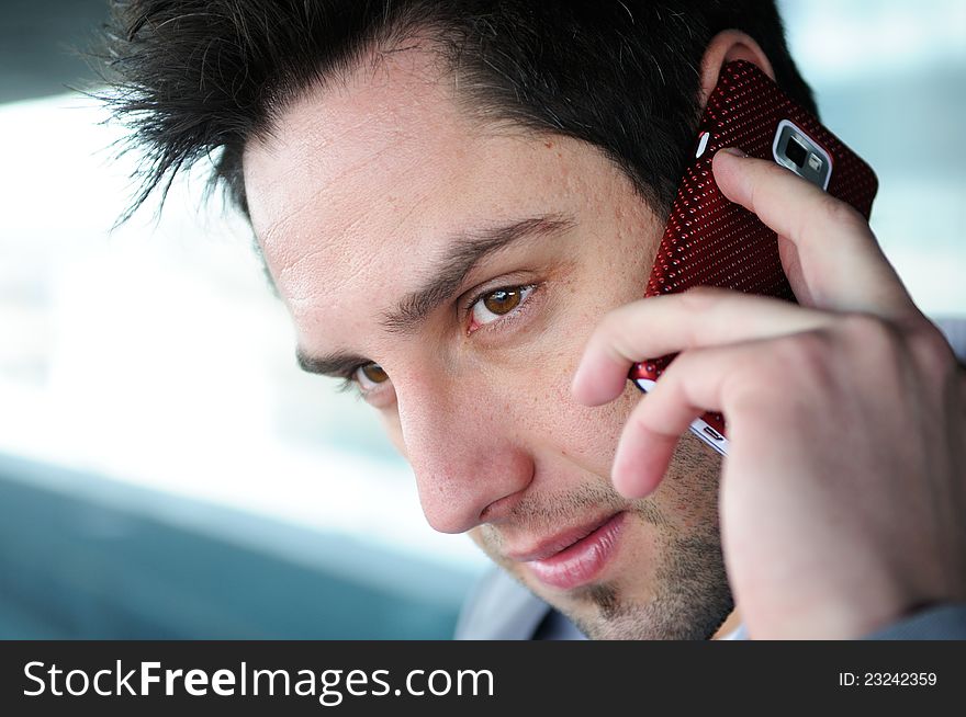 Portrait of handsome man in urban background talking on phone. Portrait of handsome man in urban background talking on phone