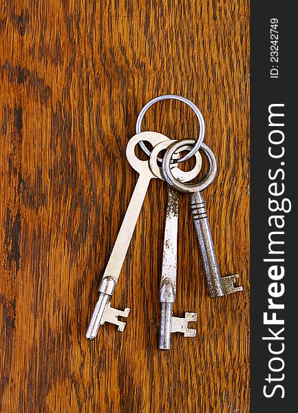 Vintage skeleton keys positioned on old scratched plank of oak wood. Vintage skeleton keys positioned on old scratched plank of oak wood