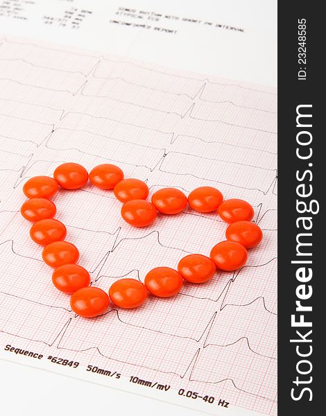 Heart of pills on electrocardiogram background