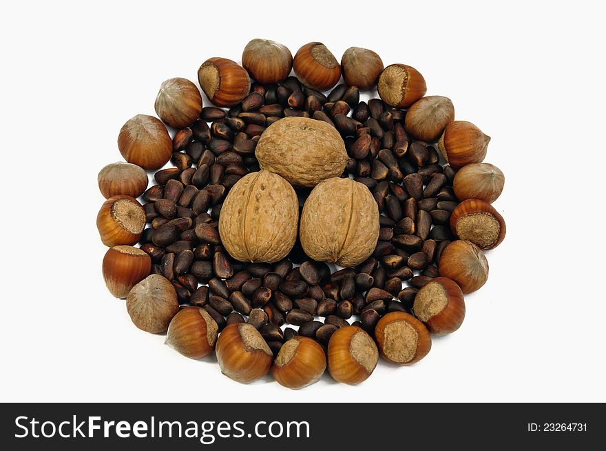 Handful of fresh hazelnuts filled up among the pine nuts, isolated on white background. Handful of fresh hazelnuts filled up among the pine nuts, isolated on white background