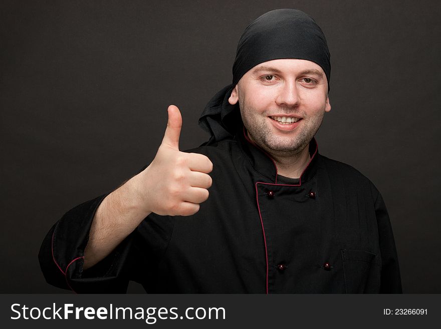 Professional chef in black uniforms showing thumbs up. Professional chef in black uniforms showing thumbs up