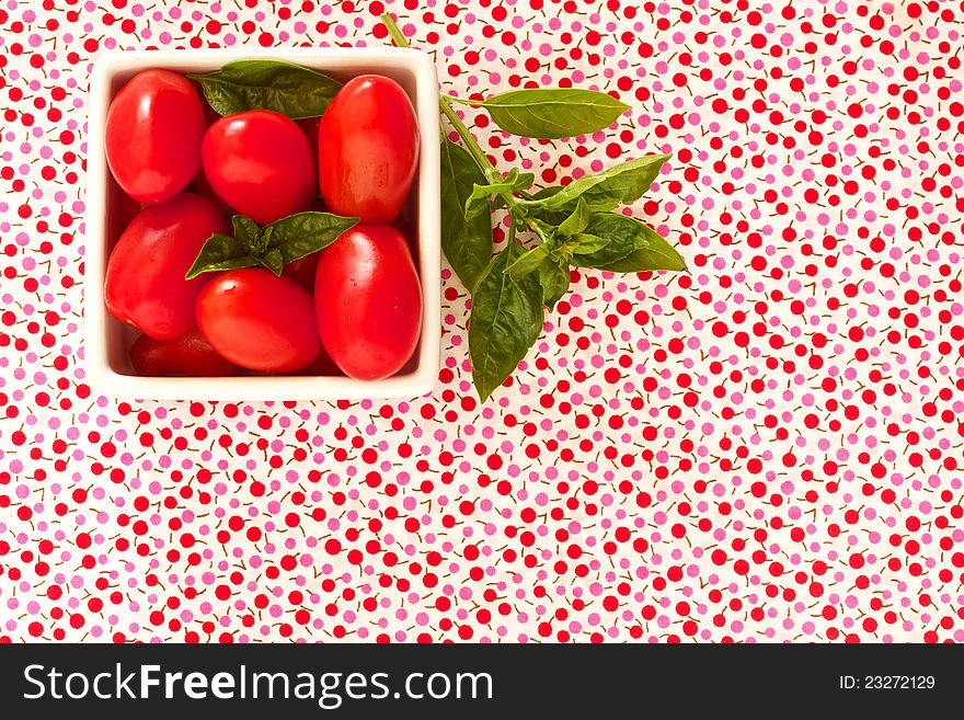 Cherry tomatoes on bright summer fabric with space for text. Cherry tomatoes on bright summer fabric with space for text