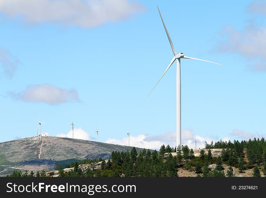 Wind power station - wind turbine against the blue sky