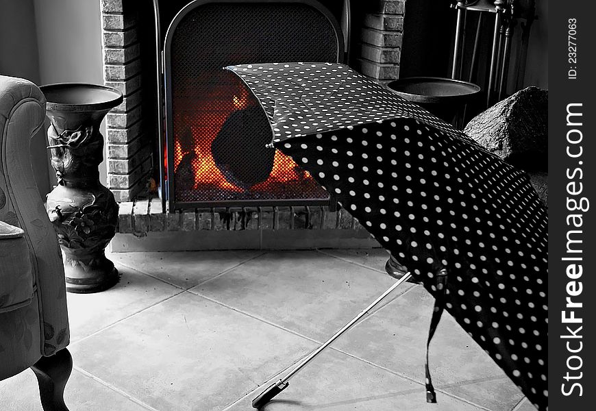 Umbrellas drying in the warmth of the fireplace at home. Umbrellas drying in the warmth of the fireplace at home