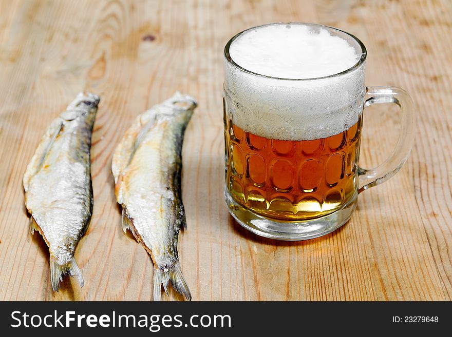 Dry salty fish and beer on a wooden background