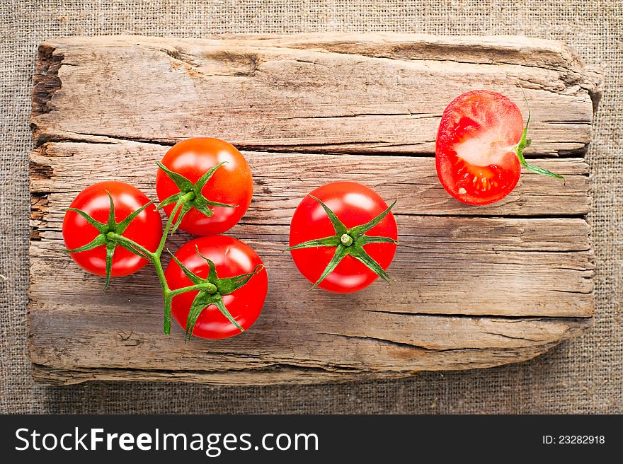 Fresh tomatoes on vintage wooden cutting board and linen background. Fresh tomatoes on vintage wooden cutting board and linen background