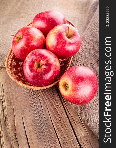 Ripe apple fruits on old wooden table with canvas tablecloth