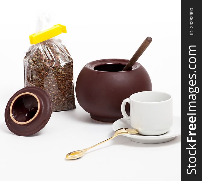 Open empty sugar pot on the white background with white coffee cup and pack of tea. Open empty sugar pot on the white background with white coffee cup and pack of tea