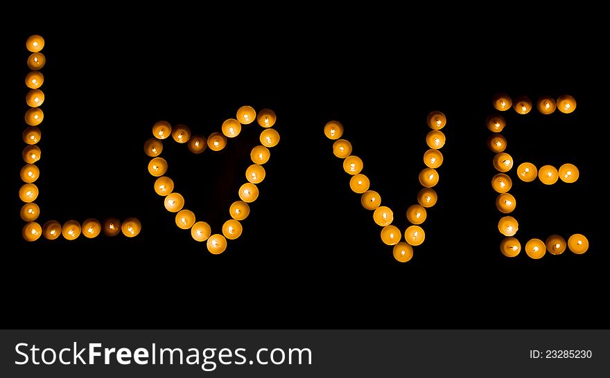 The word love is lined with candles