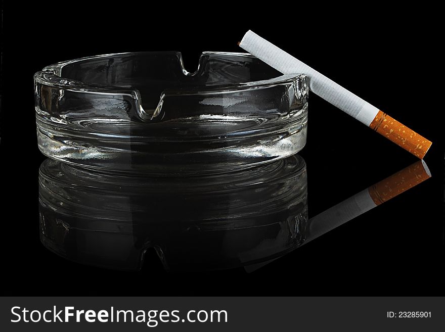 Cigarette and glass ashtray.
