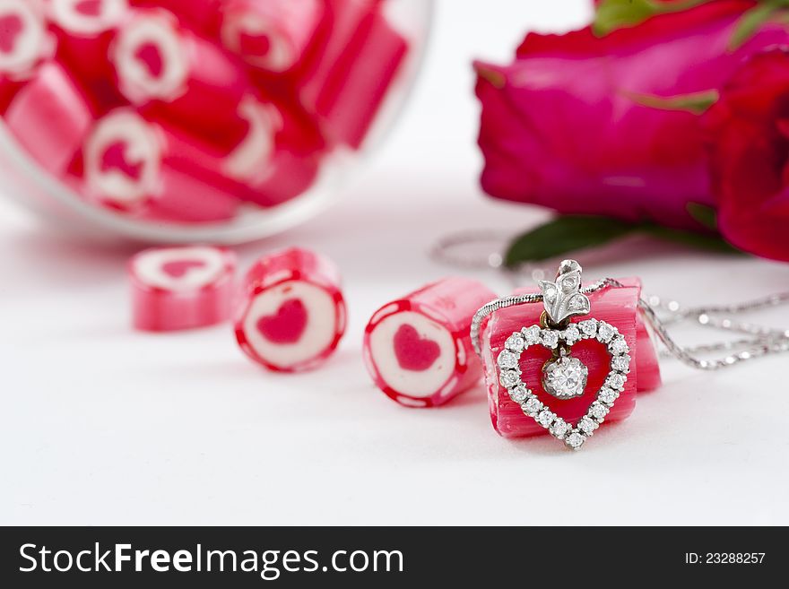 Valentine Series, Diamond pendant and candy with rose on white background