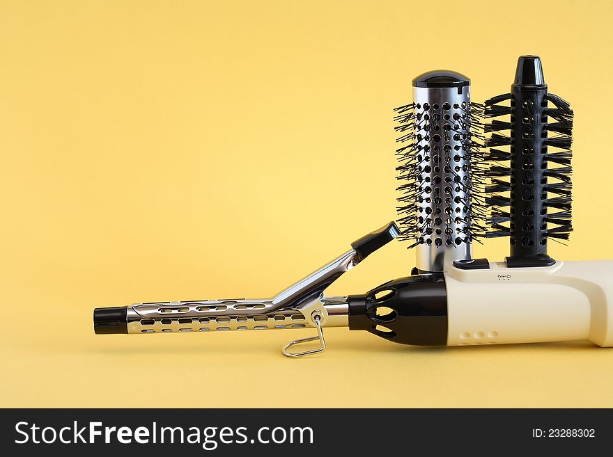 Hairdressing set with various accessories on yellow background