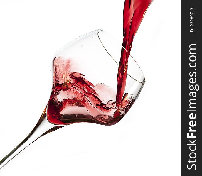 Red wine pouring into glass, isolated on white background