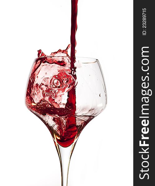 Red wine pouring into glass, isolated on white background