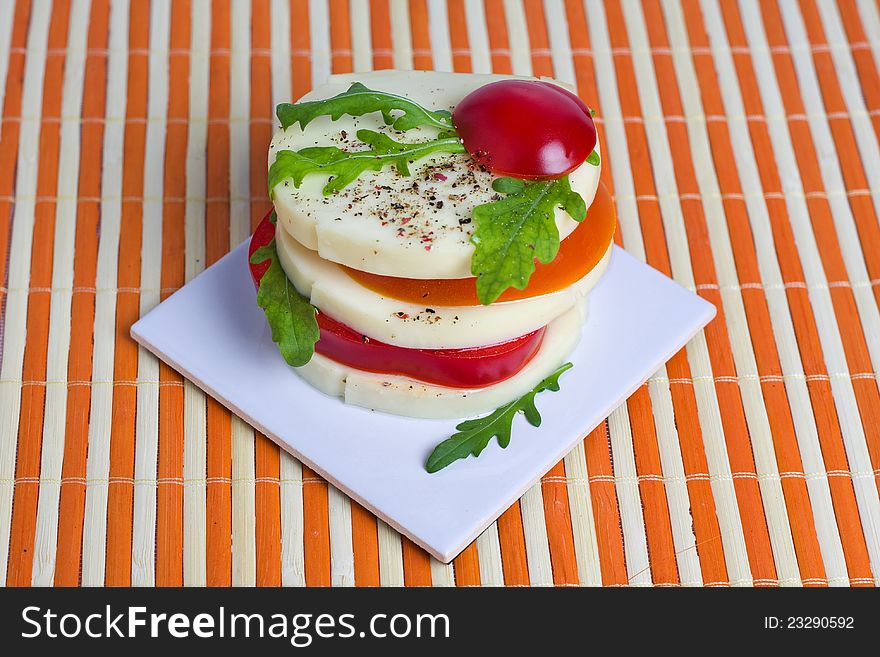 A light snack of cheese, tomato, and rocket salad. A light snack of cheese, tomato, and rocket salad