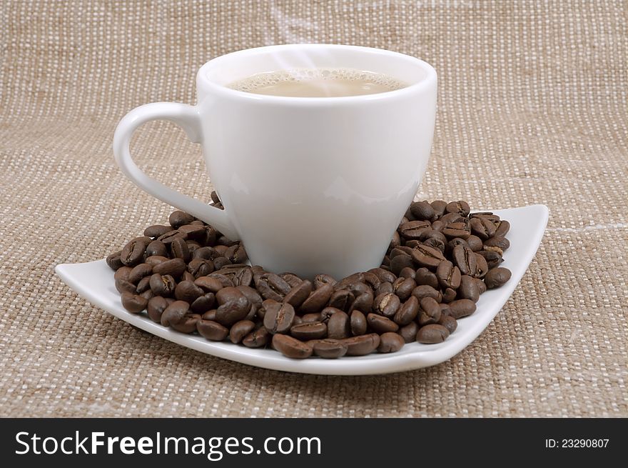 Coffee and milk and saucer with grains on a background sacking