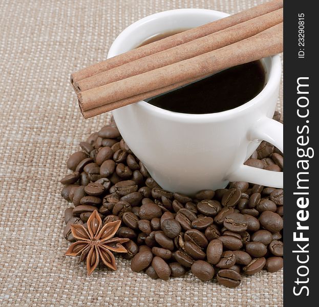 Coffee bean and anise lie on a saucer on a background hot coffee and sacking. Coffee bean and anise lie on a saucer on a background hot coffee and sacking